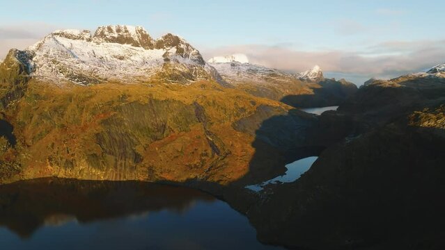 aerial view of mountains covered with snow and mountain lakes during sunrise on lofoten islands in norway