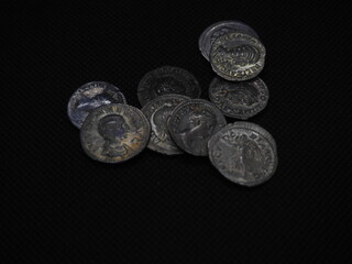 Roman gold and silver coins on a black background
