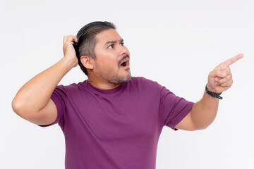 A man scratches his head looking stumped while pointing at something above and to the right....