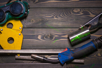 Welding concept background top view. Semi automatic welding machine and metal parts on the floor...