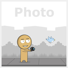 A boy with a camera photographs a bird