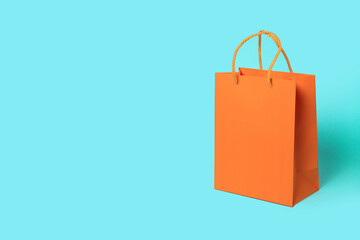 Orange paper shopping bag on blue background. Shopping sale delivery concept. Packaging gift.