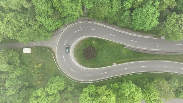 Drone footage of a car driving on the Castle Road on a foggy day in Bourscheid, Luxembourg