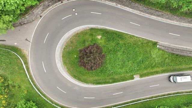 Ascending drone footage of a car driving on the Castle Road on a foggy day in Bourscheid, Luxembourg