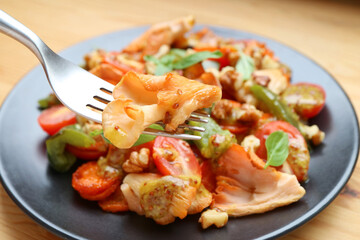 Fork Scooping Delectable Sauteed Pink Oyster Mushrooms with Colorful Vegetables