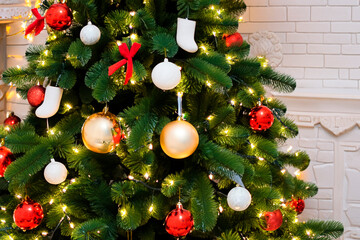 Photo of luxury gift boxes under the tree, Christmas decorations for the home, beautiful Santa gift wrapping, fireplace, holiday tree decorated with garland, baubles, traditional holiday.