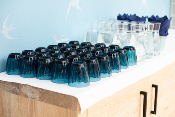 Lot of blue glass glasses on the table for water, for party