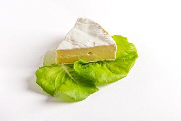 fresh delicious brie cheese and leaves of lettuce close up shallow depth of field