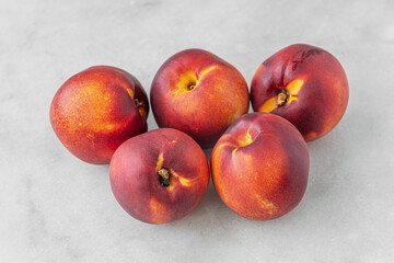ripe sweet nectarines on a white marble surface close up shallow depth of field