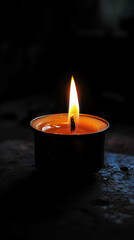 A small candle burning in the dark