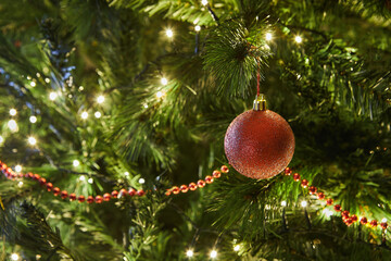 Close-Up of Christmas Tree with Ornaments and Garland with Lights