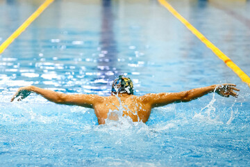 rear view male athlete swim butterfly at swimming competition, summer sports games