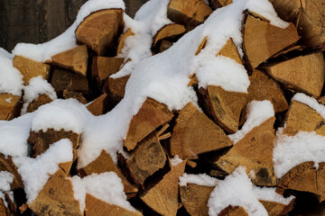 Stack of firewood snow covered in winter	