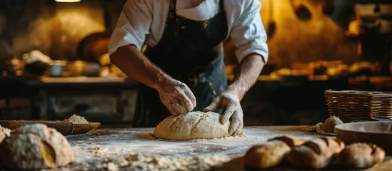 Papier Peint photo Lavable Pain Male baker kneading dough to make bread.