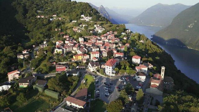 Aerial dolly at sunset with view of town of Br&egrave;, Lugano and Lake Lugano. Incredible landscape of mountains and lake. Drone shot over Mount Br&egrave;, Lugano.
