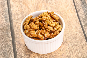 Cracked unshelled walnut in the bowl