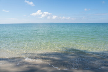 The sea is full of water lapping on the beautiful white sand beach.