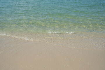 The sea is full of water lapping on the beautiful white sand beach.