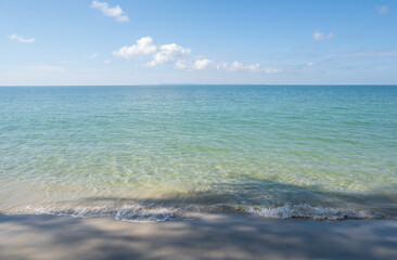 The sea is full of water lapping on the beautiful white sand beach.