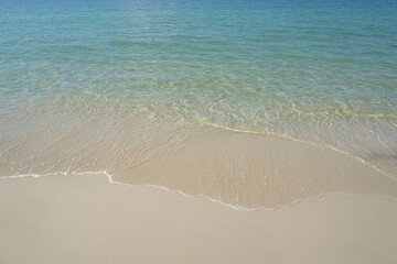 The sea is full of water lapping on the beautiful white sand beach.