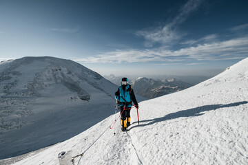 a girl climber walks along the snow-covered slope of Elbrus to the top