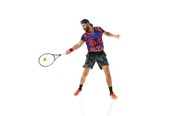 Bearded young man in colorful sportswear playing tennis, in motion with racket isolated over white background. Concept of professional sport, movement, competition, action. Ad