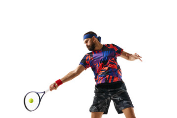 Concentrated bearded young man, tennis player hitting ball with racket, playing isolated over white...