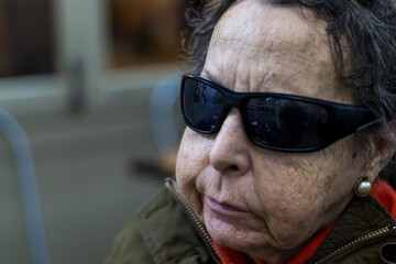 blind elderly woman walking in the afternoon through the main square of madrid