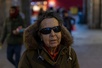 blind elderly woman walking in the afternoon through the main square of madrid