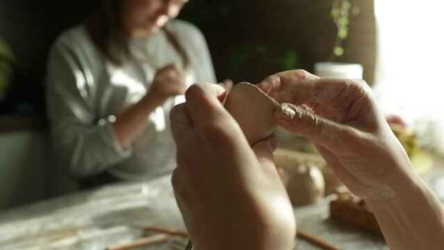 A woman makes a clay product with her hands - a ceramic pot. Close-up. Creative hobby.