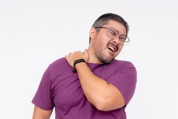 A middle aged man grimaces in pain over sore trapezius muscles. Pulling a muscle or DOMS the next day after a workout. Isolated on a white background. - obrazy, fototapety, plakaty