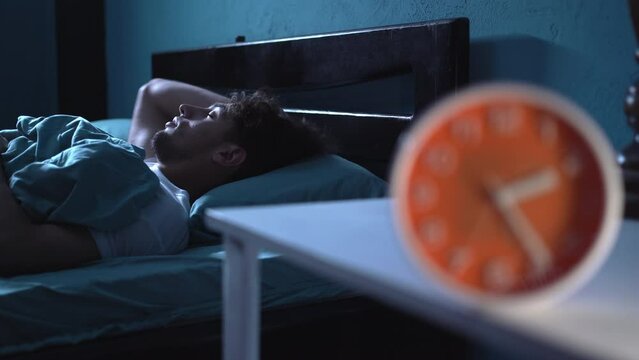 Sleepless, young arabic man suffering from insomnia, sleep apnea or stress. Tired and exhausted guy. Headache or migraine. Awake in the night.