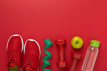 Sport equipment with tape measure on color background, top, view. Weight loss concept