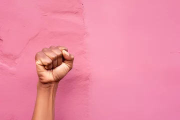 Foto op Canvas Raised fist of a woman on pink background with copy space. International women's day and the feminist movement concept. March 8. Independence, freedom, empowerment, and activism for women rights © ratatosk