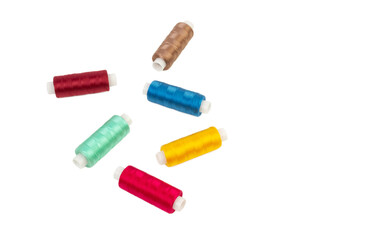 Six multi-colored nylon threads on bobbins on a white background