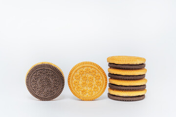 chocolate and milk round cookies on a white background. sandwich of two types of cookies on a light background. a subject photo session of sweet cookies in a photo studio