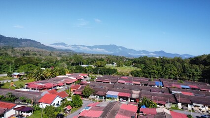 a view from drone roof top houses and himalayan mountains at kuala kangsar perak malaysia
