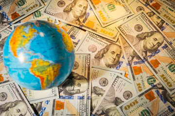 Global economy, globe on heap of us dollar  banknotes