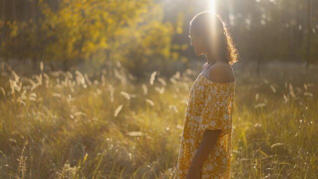 close up face Young Beautiful Woman in yellow sundress Standing in autumn Forest and Looking around. girl Enjoys Being Alone with Nature, Admiring its Beauty. Slow Motion Cinematic Shot