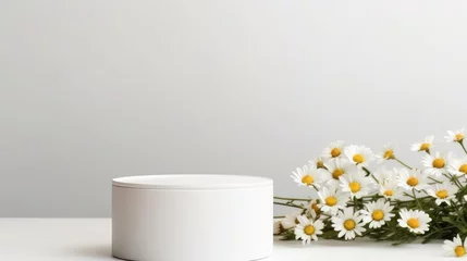 Tuinposter Empty cylindrical podium or plinth with chamomile flowers on a white background. Blank shelf product standing background © sambath