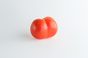 Wrinkled skin of red tomatoes and looks like butt or bottom-shaped.