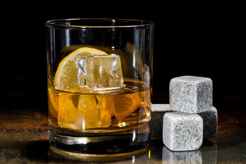 glass of whiskey with cooling stones. Dark gray bourbon stones.