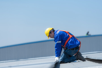 A technician is installing solar panels on the roof of the warehouse to change solar energy into...