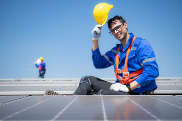 Technician repairing solar panels take off his hat and rest in the scorching sun on a factory roof...