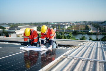 Engineer and technician working on the solar panel on the warehouse roof to inspect the solar...