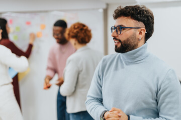 Fototapeta premium Multiracial team in a corporate office collaborating and strategizing to expand the business. Focused on market analysis, financial planning, and innovation.