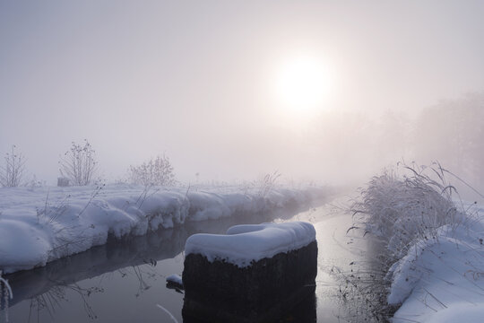 Fototapeta Różowy mglisty wschód słońca, zimowy krajobraz i rzeka