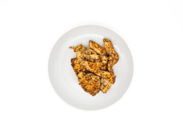 Homemade roasted chicken-breast fillet marinated with herbs and spices, served on a white plate. Isolated on white with copy space. Top view or flat lay.