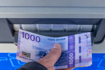 Norway money, 1000 Norwegian kroner banknote withdrawn from an ATM or inserted into a cash deposit machine, Financial concept, Home budget and cash payments - obrazy, fototapety, plakaty