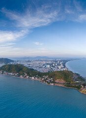 Panoramic coastal Vung Tau view from above, with waves, coastline, streets, coconut trees, Mount Nho in Vietnam behind the statue of Christ the King